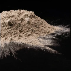 Pure-Flo B80 Natural Bleaching Clay 14 kg, pile of light tan powder on a black surface