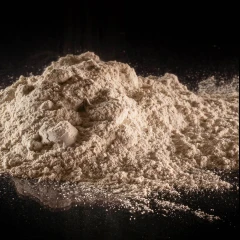 T-5 Calcium Bentonite Clay 9 kg, 3.5 Gallon, heap of light tan clay powder on a black surface