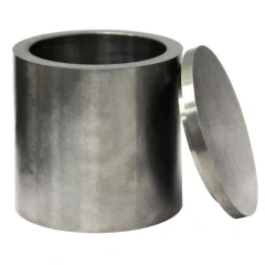 Polished Tungsten Carbide Grinding Jar with Lid, dark grey metal cylinder with flat lid leaning on it