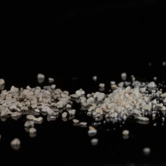 ZeoClear Y granular attapulgite, heap of light tan granules on a dark background – view 4