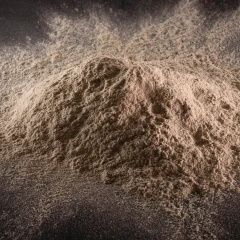 T-5 Calcium Bentonite Clay, heap of light tan powder on a dark background