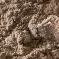 T-5 Calcium Bentonite Clay, heap of light tan powder on a dark background – view 3